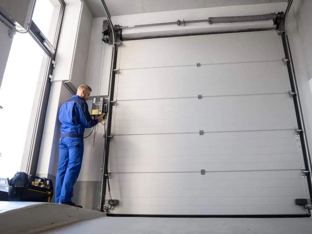 Technician servicing a commercial overhead garage door